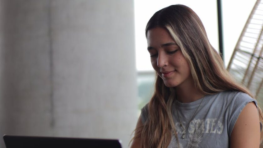 a woman sitting at a table with a laptop